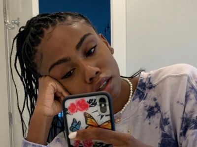 Zahra Savannah Rock is resting her head with her right hand as she is taking a selfie with the other.